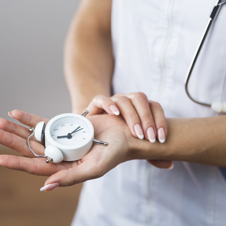 woman-hands-holding-little-clock